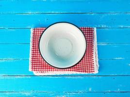 empty round white metal plate on a red-white textile napkin photo