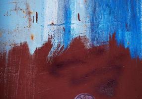 brown iron texture of rusty sheet with remains of blue paint photo