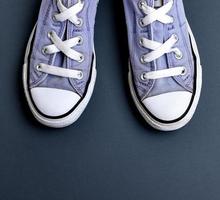 pair of well-worn old textile lilac sneakers with white laces photo