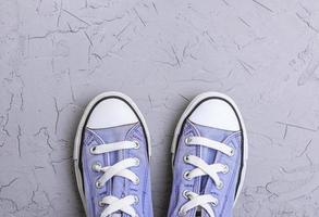 pair of old worn purple  sneakers with white laces photo