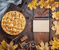 baked whole round apple pie on a brown wooden board, puff pastry photo