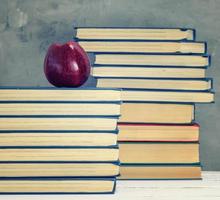 ripe red apple on a stack of books photo