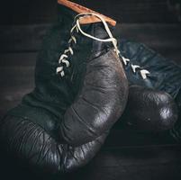 pair of very old shabby black leather boxing gloves photo