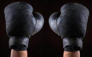 old boxing gloves dressed on man's hands photo