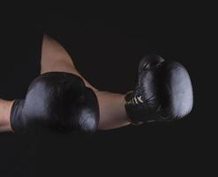 men's hands are wearing old leather  boxing gloves photo
