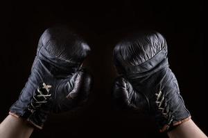 elevado arriba brazos de un atleta vestido en cuero marrón boxeo guantes foto