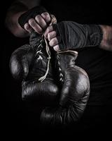 very old boxing sports gloves in men's hands photo