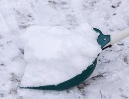 plastic shovel with a bunch of white snow outside photo