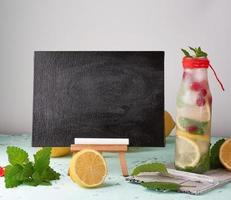 empty black chalk board for writing a summer drink recipe and a glass with lemonade photo