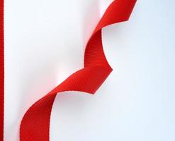 twisted red textile belt with a coarse fiber on a white background photo