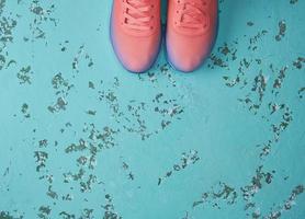 pair of  pink sneakers with  laces on a green background photo