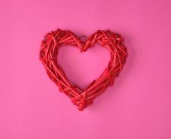 one wicker red heart on a pink background photo