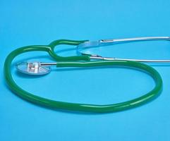 green medical stethoscope on blue background photo