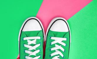 pair of green textile sneakers on an abstract multicolored background photo
