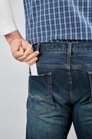 man puts an empty white paper business card in his back jeans pocket photo