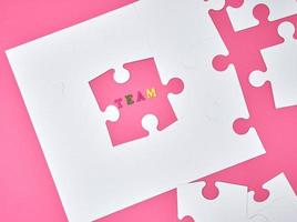 white big puzzles on a pink background, the inscription team, photo