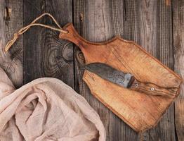 empty old brown wooden cutting board with handle and gray textile napkin photo