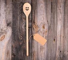 de madera cuchara con incrustado ojos y un sonrisa, vacío marrón papel etiqueta foto