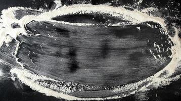 white wheat flour scattered on a black table, inscription frame photo