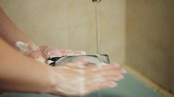 Waschen ein Smartphone mit Seife während ein Epidemie von Coronaviren und Infektion. Hygiene Mittel. halt Coronavirus Pandemie, Hypochondrie COVID-19. video