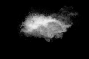 White powder explosion cloud against black background.White dust particle splash. photo