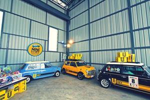 Bangkok, Thailand - January 29, 2023 Blue, Yellow and Black Mini Austin classic car parking in garage with yellow box on top roof and zinc wall background in vintage color style. Small vehicle photo