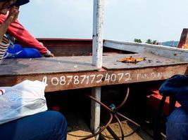 Cilegon, Indonesia in 2018. A passenger boat telephone number on Little Merak Island, photo