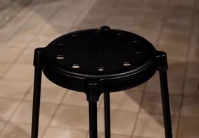 Black round stool on the background floor tiles. photo