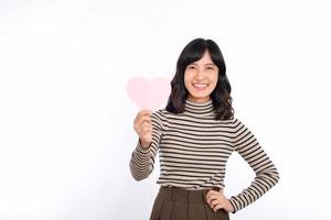 Beautiful young asian woman holding a paper heart while standing against white background. Beautiful young asian woman with paper heart. photo