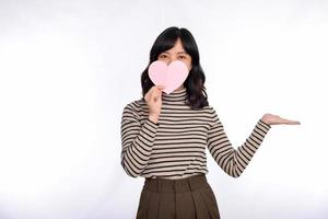 Beautiful young asian woman holding a paper heart while standing against white background. Beautiful young asian woman with paper heart. photo