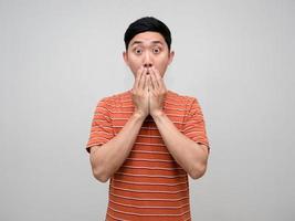 Asian man orange striped feels amazed gesture close his mouth isolated photo