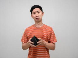 asiático hombre a rayas camisa siente triste acerca de No dinero en su billetera, pobre hombre concepto foto