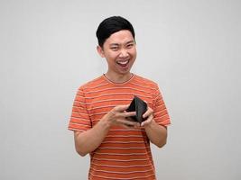 Positive man orange striped shirt holding wallet happy with earn money,Rich man holding wallet feels success photo