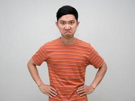 Asian man striped shirt stand hand at waist feels angry looking at you isolated photo