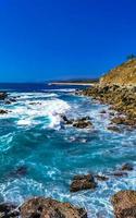 Beautiful rocks cliffs view waves at beach Puerto Escondido Mexico. photo