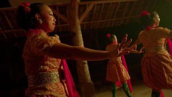 Indonesian people dance together in happiness in warm lighting and orange dress in their body video