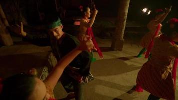 Javanese women celebrate the new year by dancing together in orange dresses and green scarf inside the traditional dance festival video