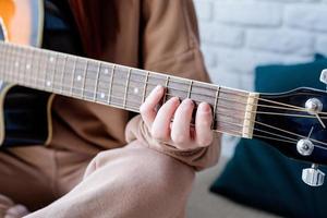 de cerca de mujer jugando guitarra a hogar foto