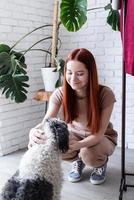 joven mujer jugando con su linda perro a hogar foto