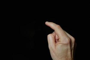 index finger pointing at the screen, black background photo