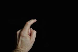 index finger pointing at the screen, black background photo