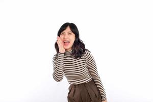 Happy young asian woman, professional entrepreneur standing in casual clothing, open mouths raising hands shout announcement, white background photo