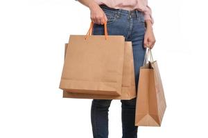 Close up of woman hand with casual clothing holding shopping paper bag isolated on white background photo