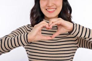 Young asian woman hands making a heart shape on a white isolated background photo
