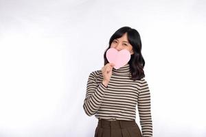 Beautiful young asian woman holding a paper heart while standing against white background. Beautiful young asian woman with paper heart. photo