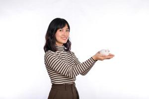 Portrait of young Asian woman casual uniform holding white piggy bank isolated on white background, Financial and bank saving money concept photo