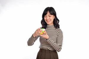 Asian woman holding a rubik cube standing on white background. solving cubic problems, problem solution and making strategic moves concept photo