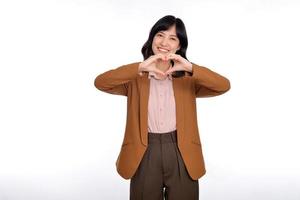 Young Asian woman showing hand heart sign isolated on white background, Spreading love and happiness concept photo