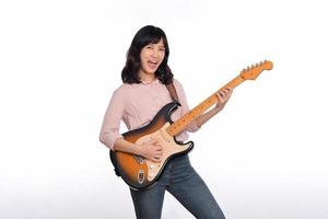 Asian woman playing a vintage sunburst electric guitar isolated on white background photo