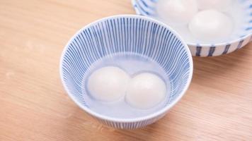 Tang yuan, tangyuan, yuanxiao in a small bowl. Delicious asian traditional festive food rice dumpling balls with stuffed fillings for Chinese Lantern Festival, close up. photo